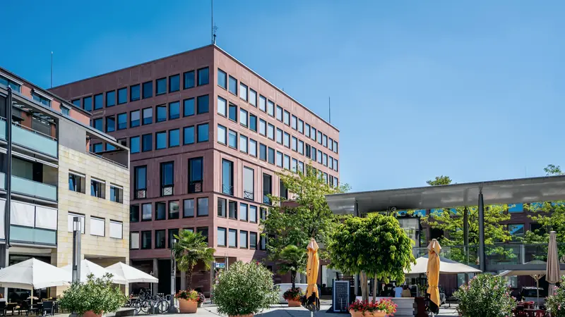 Öffentliches Verwaltungsgebäude mit belebtem Vorplatz
